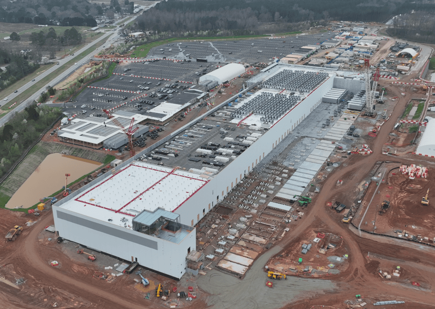 Program directors reviewing construction plans on an active site